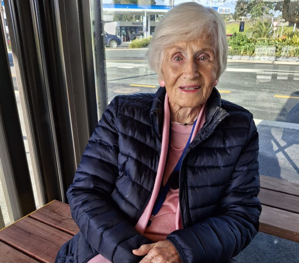 Elderly lady sitting at bus stop